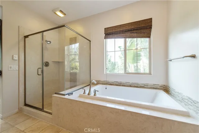 a spacious bathroom with a tub sink shower and mirror