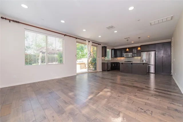 an empty room with kitchen view and appliances