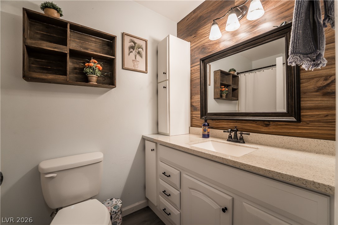 1324 Appaloosa Road Boulder City, NV 89005 - Photo 22 of 42 A well-appointed bathroom features a wood-paneled accent wall, providing a unique and natural touch.