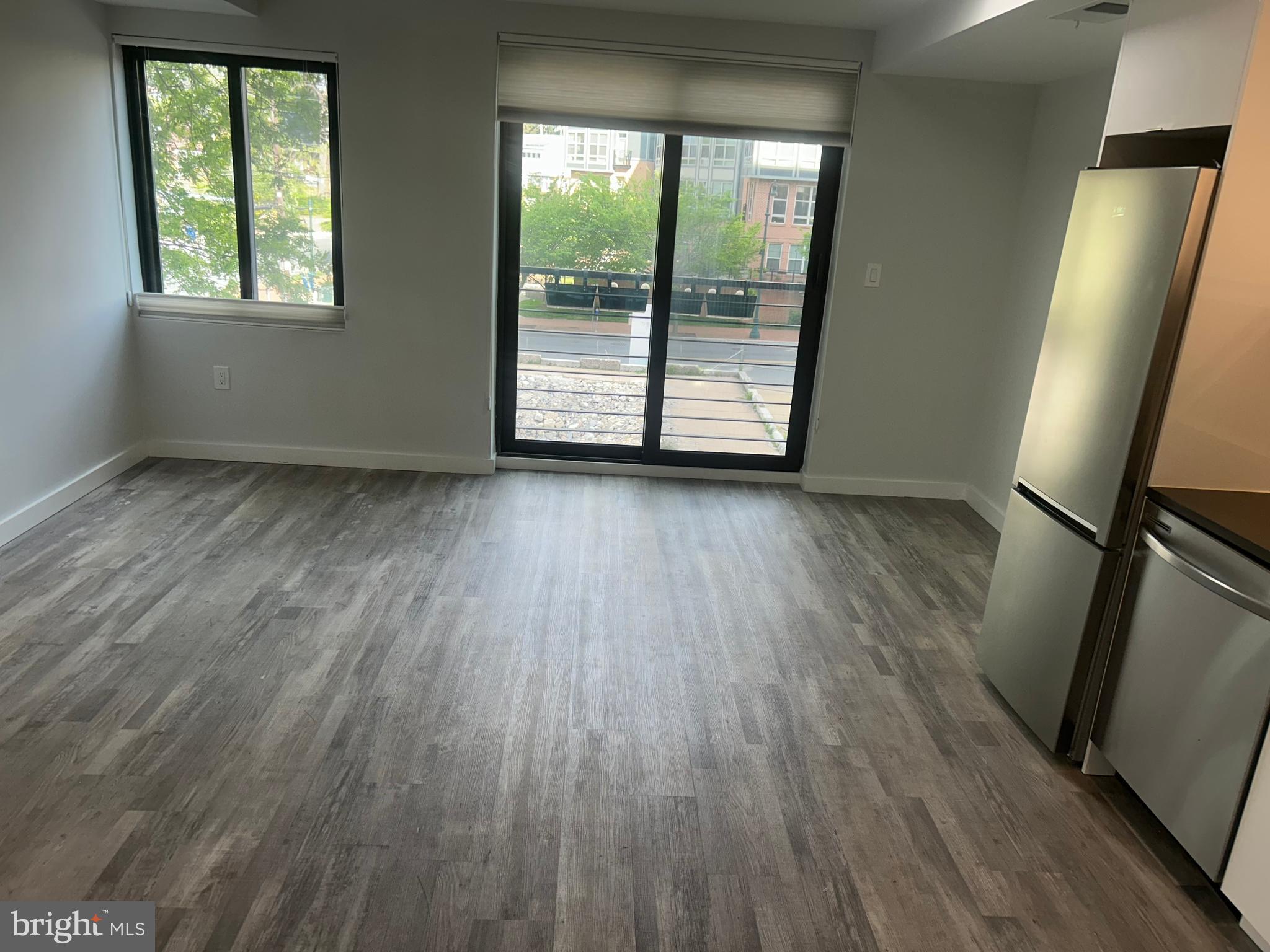 700 Roeder Road, Unit 201 Silver Spring, MD 20910 - Photo 8 of 15 an empty room with wooden floor and windows