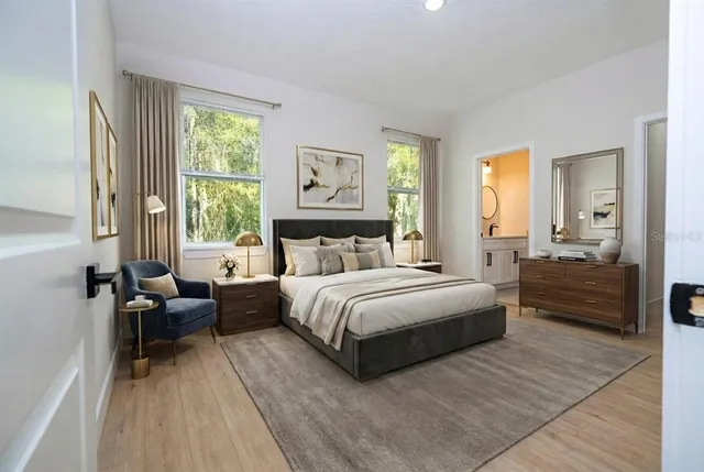 a bedroom with a bed wooden floor and windows