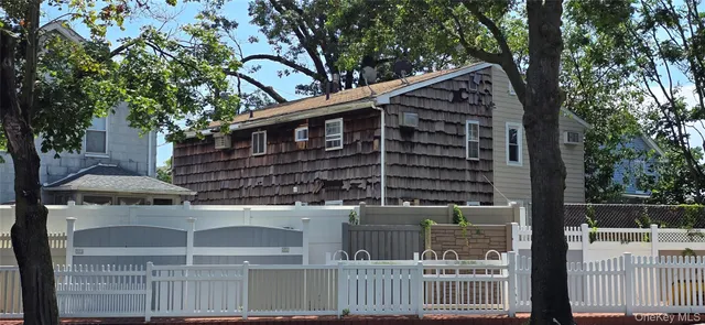 a front view of a house with a tree