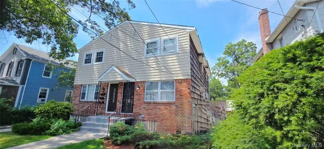 a front view of a house with plants