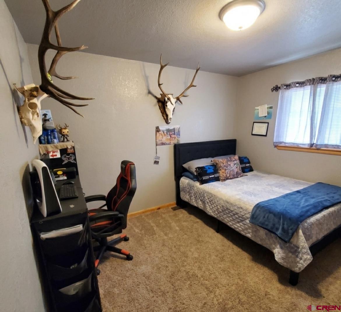 816 Main Street Manassa, CO 81141 - Photo 16 of 23 a bedroom with a bed a desk and chair