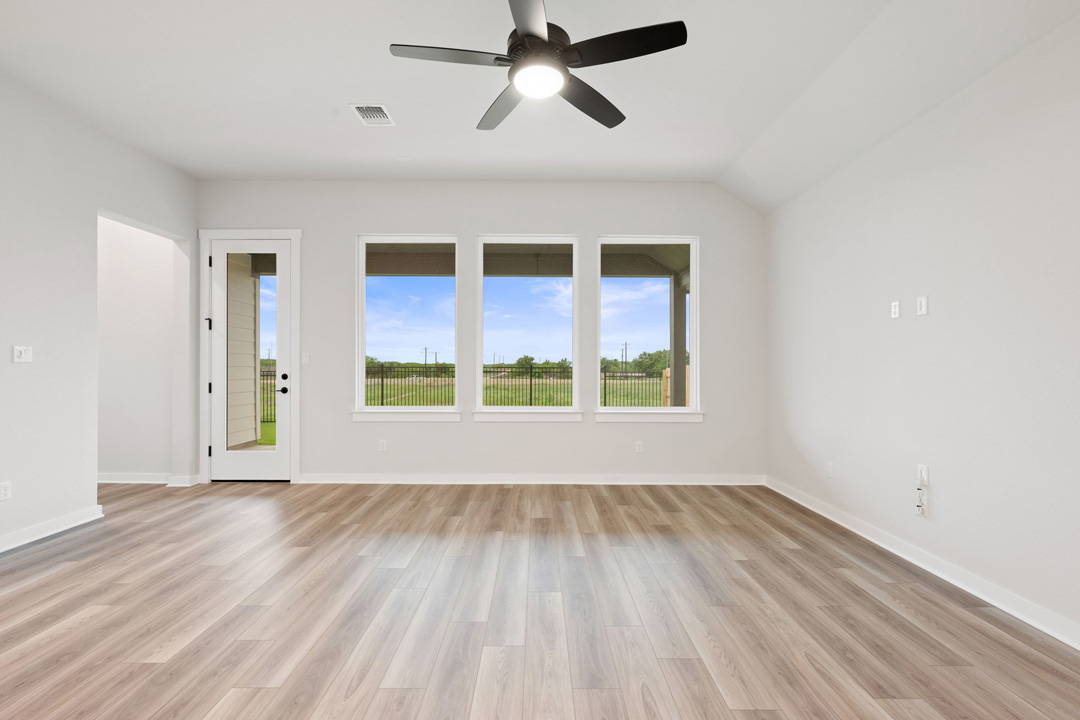 16201 Smithers Road Manor, TX 78653 - Photo 12 of 40 a view of an empty room with a window and wooden floor