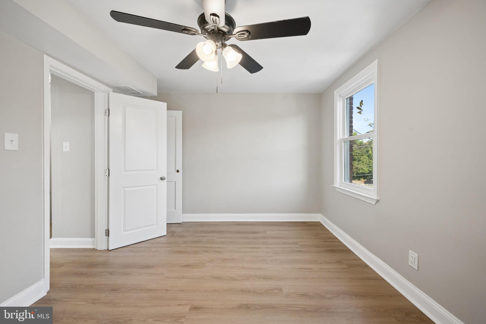 3548 Benzinger Road Baltimore, MD 21229 - Photo 15 of 40 an empty room with wooden floor ceiling fan and windows