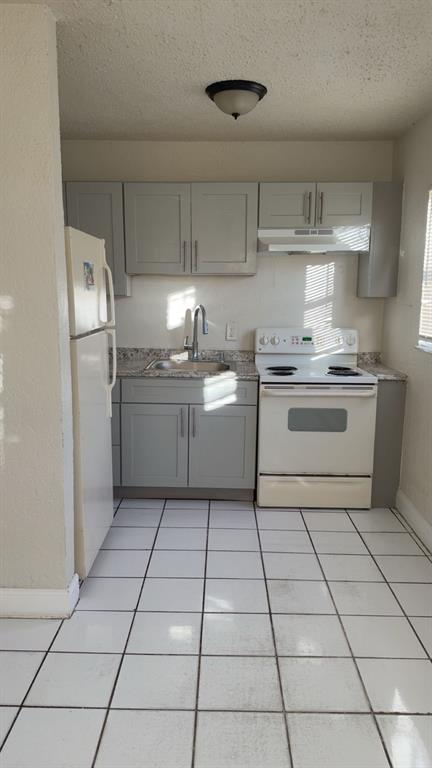 720 Southwest 7th Street, Unit 1 Dania Beach, FL 33004 - Photo 2 of 13 a kitchen with stainless steel appliances a sink and cabinets