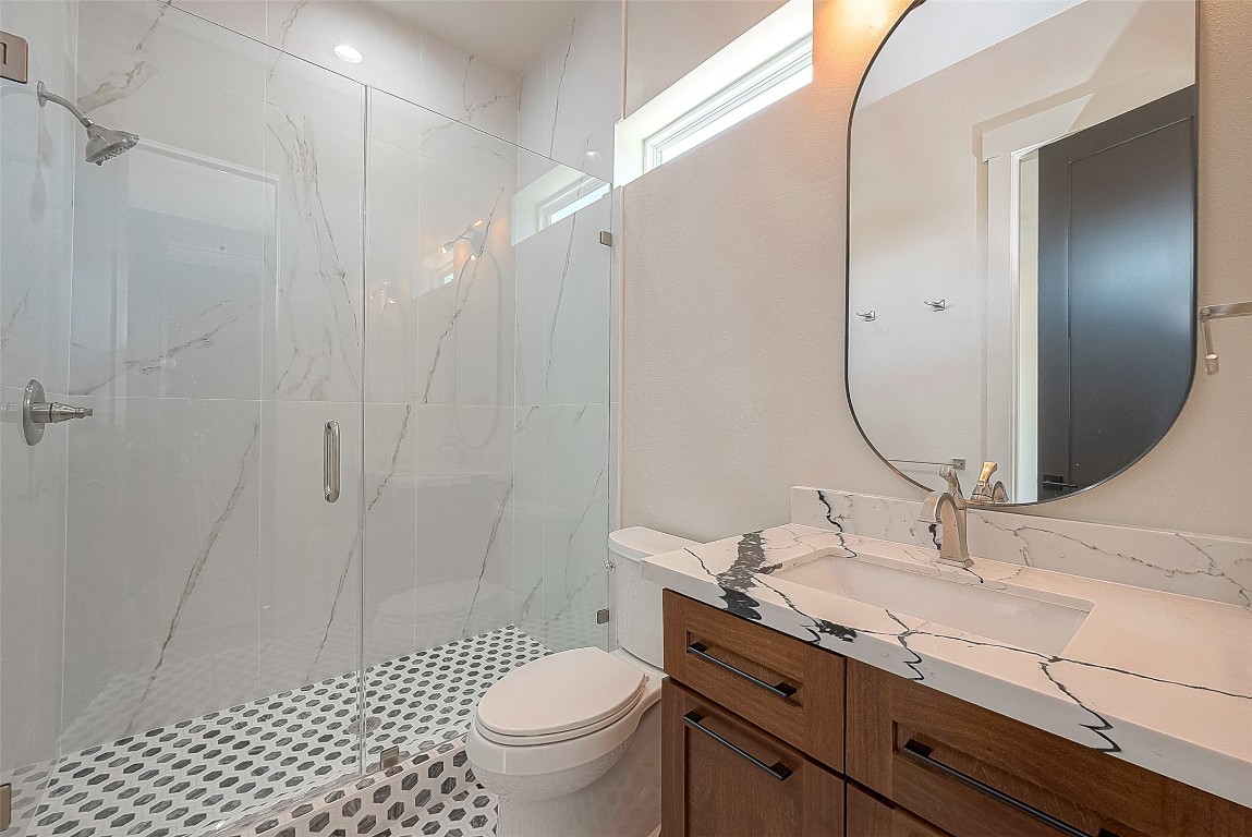 5510 Bosque Street Houston, TX 77056 - Photo 27 of 50 a bathroom with a granite countertop sink toilet a mirror and shower