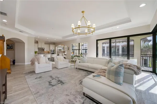 a living room with furniture chandelier and a large window