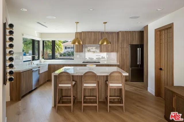 a kitchen with stainless steel appliances granite countertop a table and chairs in it