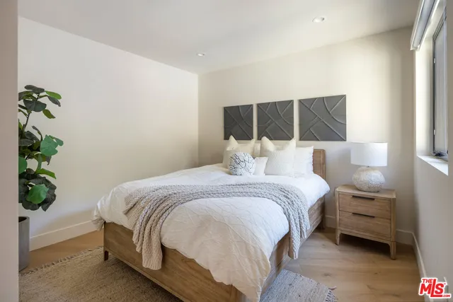 a bedroom with a bed and a potted plant