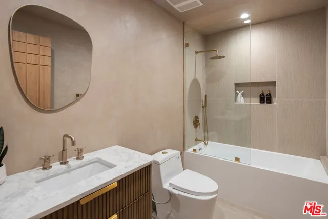 a bathroom with a granite countertop sink toilet and shower