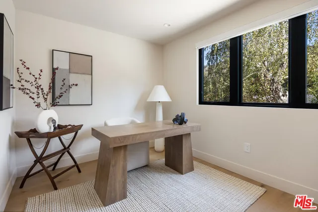 a view of a workspace with furniture and a window