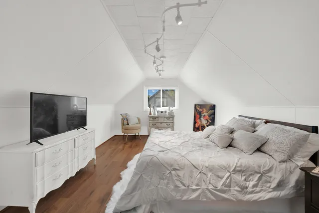 a bedroom with a bed and a flat screen tv