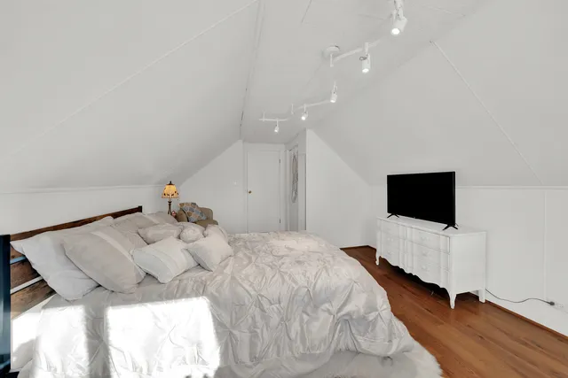 a bedroom with a bed window and a flat screen tv