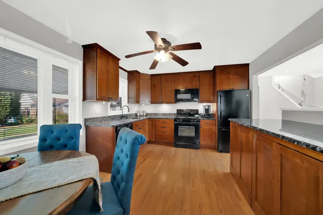 a kitchen with granite countertop wooden floors and wooden cabinets