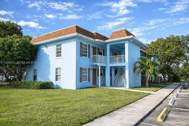 a front view of house with yard and trees in the background