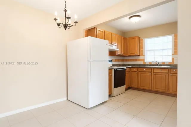 a kitchen with a white stove refrigerator and cabinets