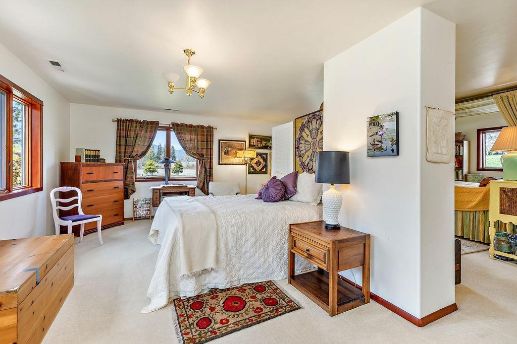 2076 Upper Applegate Road Jacksonville, OR 97530 - Photo 28 of 35 a bedroom with furniture and a chandelier