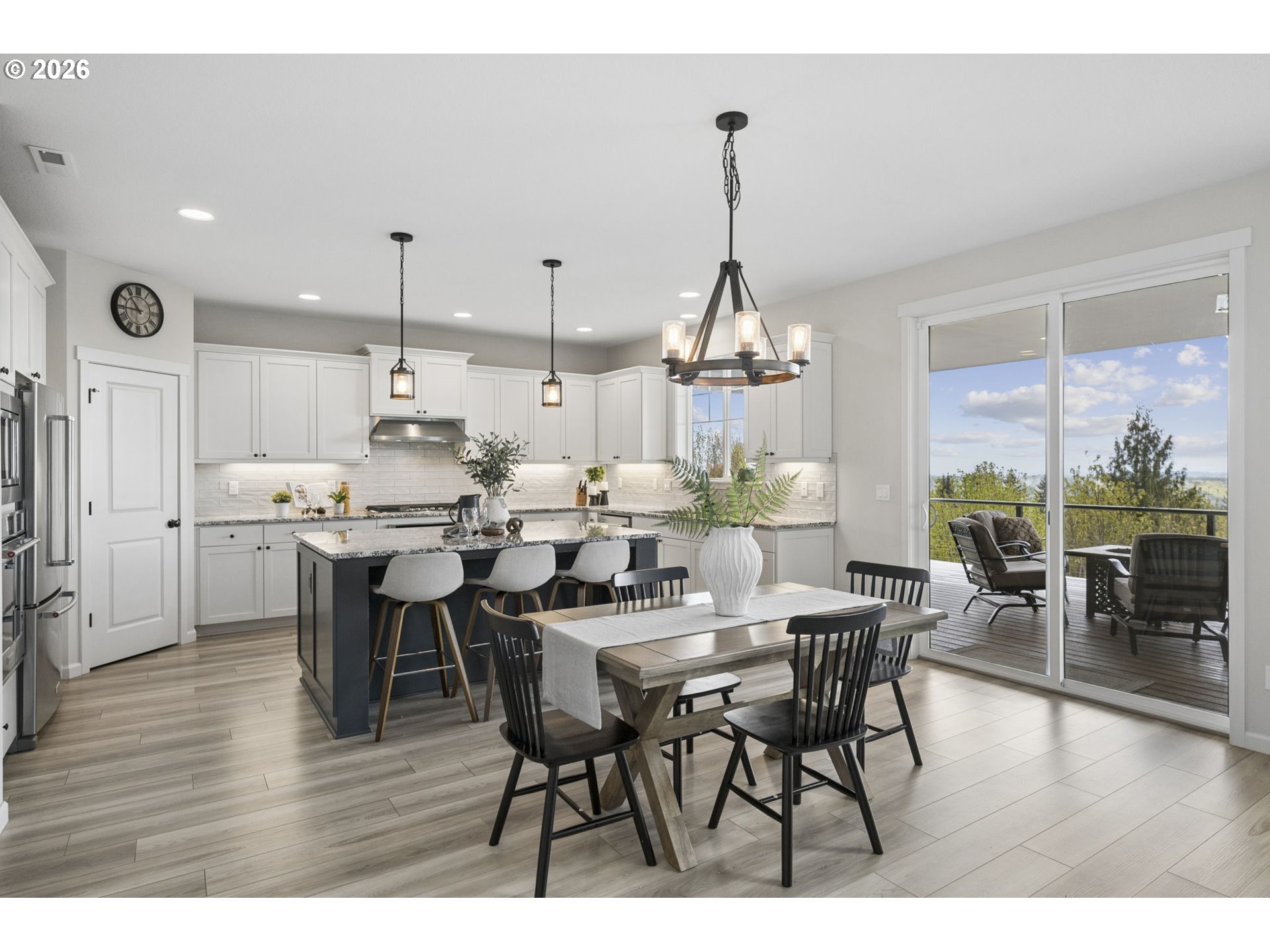 18255 Southeast Vista View Court Sandy, OR 97055 - Photo 12 of 48 a view of a dining room and livingroom with furniture wooden floor a rug a painting and a chandelier