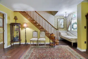 a bed sitting in a spacious bedroom next to a window and a chandelier