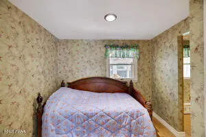a living room with furniture a flat screen tv and a large window