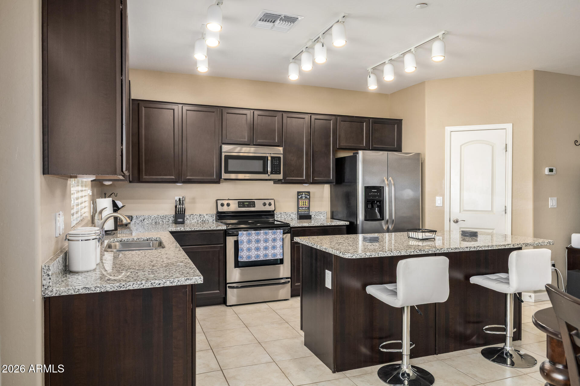 2150 West Alameda Road, Unit 1181 Phoenix, AZ 85085 - Photo 8 of 46 a kitchen with kitchen island granite countertop a sink counter top space appliances and cabinets