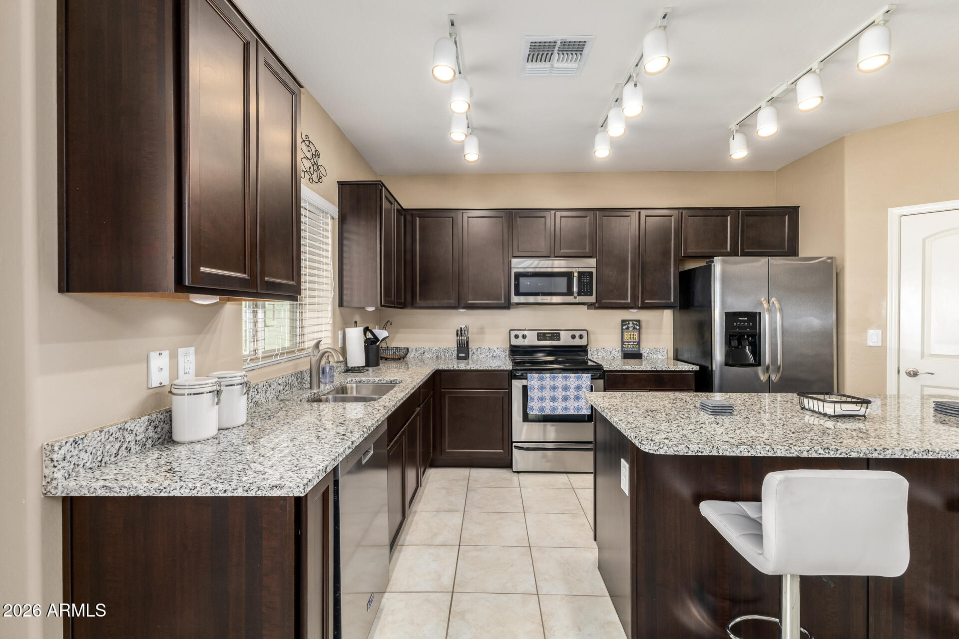 2150 West Alameda Road, Unit 1181 Phoenix, AZ 85085 - Photo 9 of 46 a kitchen with granite countertop kitchen island stainless steel appliances a sink stove top oven and refrigerator