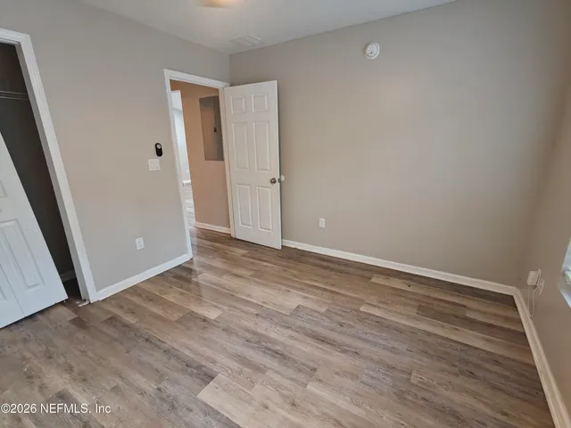 a view of an empty room with wooden floor
