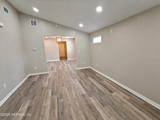 a kitchen with stainless steel appliances granite countertop a sink a refrigerator and a wooden floor