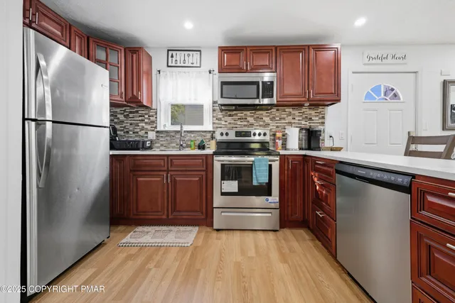 a kitchen with stainless steel appliances granite countertop a refrigerator and a stove top oven