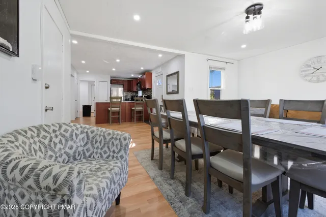 a living room with furniture and a dining table with kitchen appliances