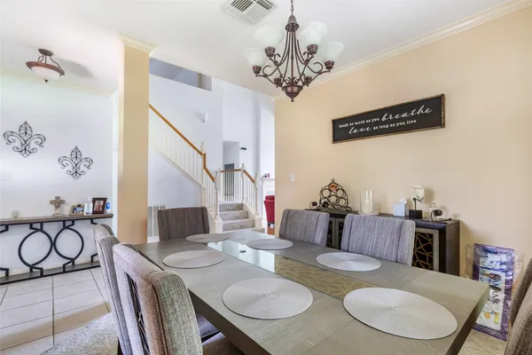 a view of a dining room with furniture a chandelier and wooden floor