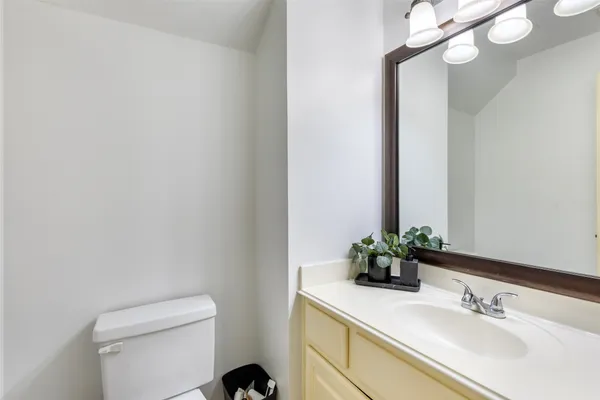 a bathroom with a sink vanity granite and toilet