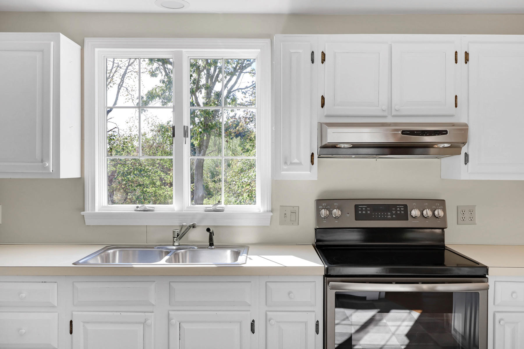 21 Briar Spring Road Orleans, MA 02653 - Photo 13 of 65 a kitchen with granite countertop a stove a sink and dishwasher next to a window
