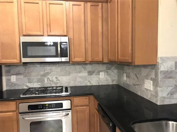 a kitchen with granite countertop a stove and a microwave