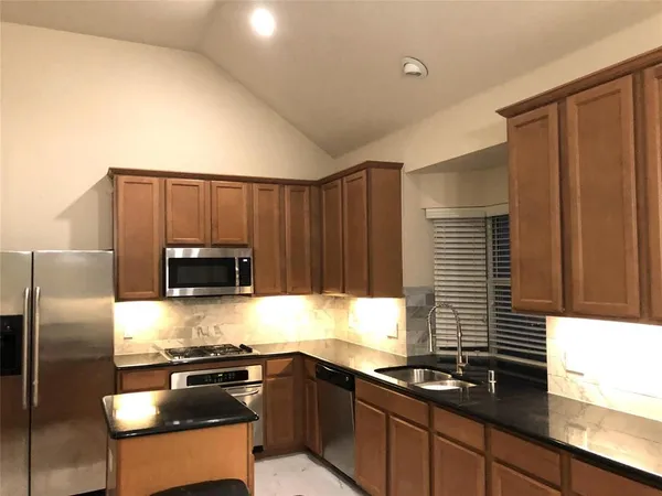 a kitchen with a sink a stove cabinets and refrigerator