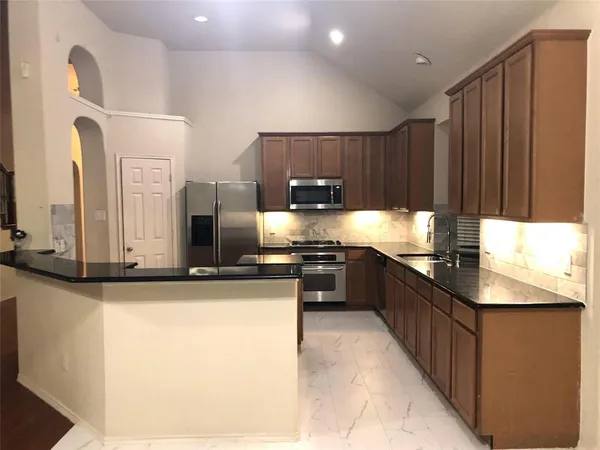 a large kitchen with kitchen island granite countertop a sink and counter space