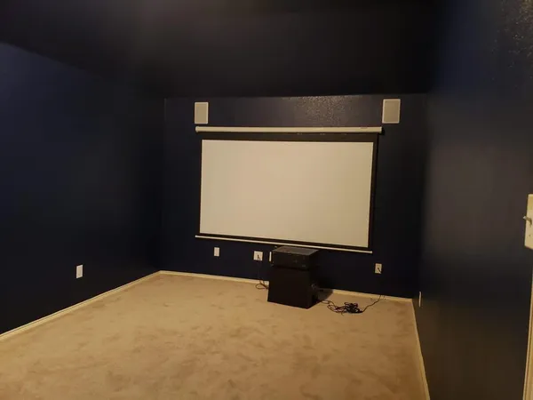 a view of an empty room with wooden floor and windows