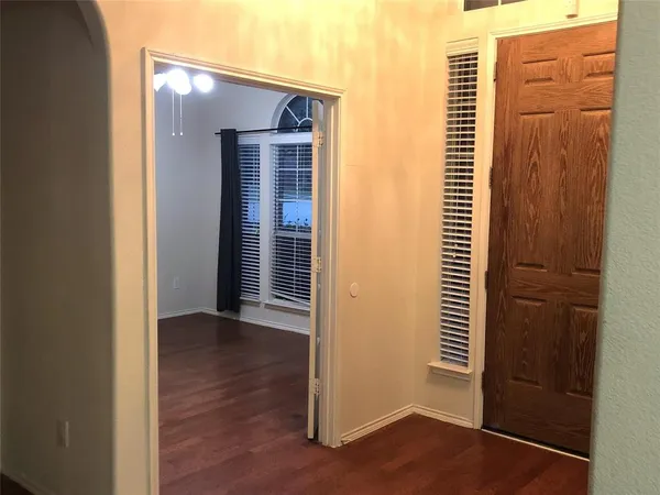 a view of a room with wooden floor and a window