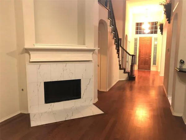a view of a livingroom with wooden floor and a fireplace