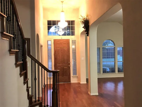 a view of a hallway with wooden floor and staircase