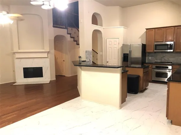 a kitchen with stainless steel appliances a stove top oven a sink and a refrigerator