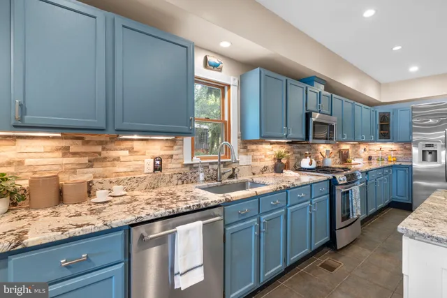 a kitchen with stainless steel appliances granite countertop wooden cabinets a sink and dishwasher