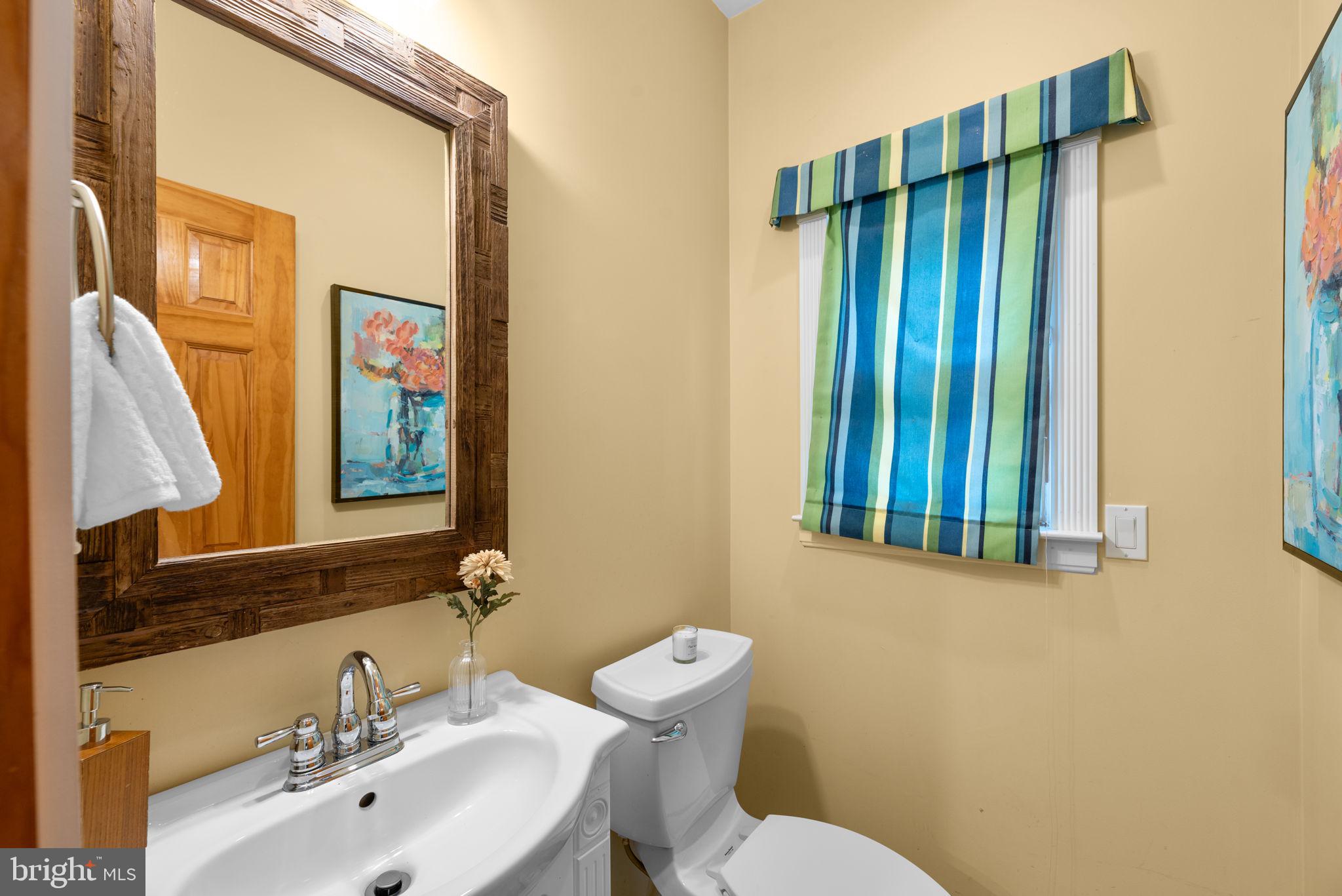 7674 Pine Knob Road Pasadena, MD 21122 - Photo 15 of 59 a bathroom with a sink a toilet and mirror