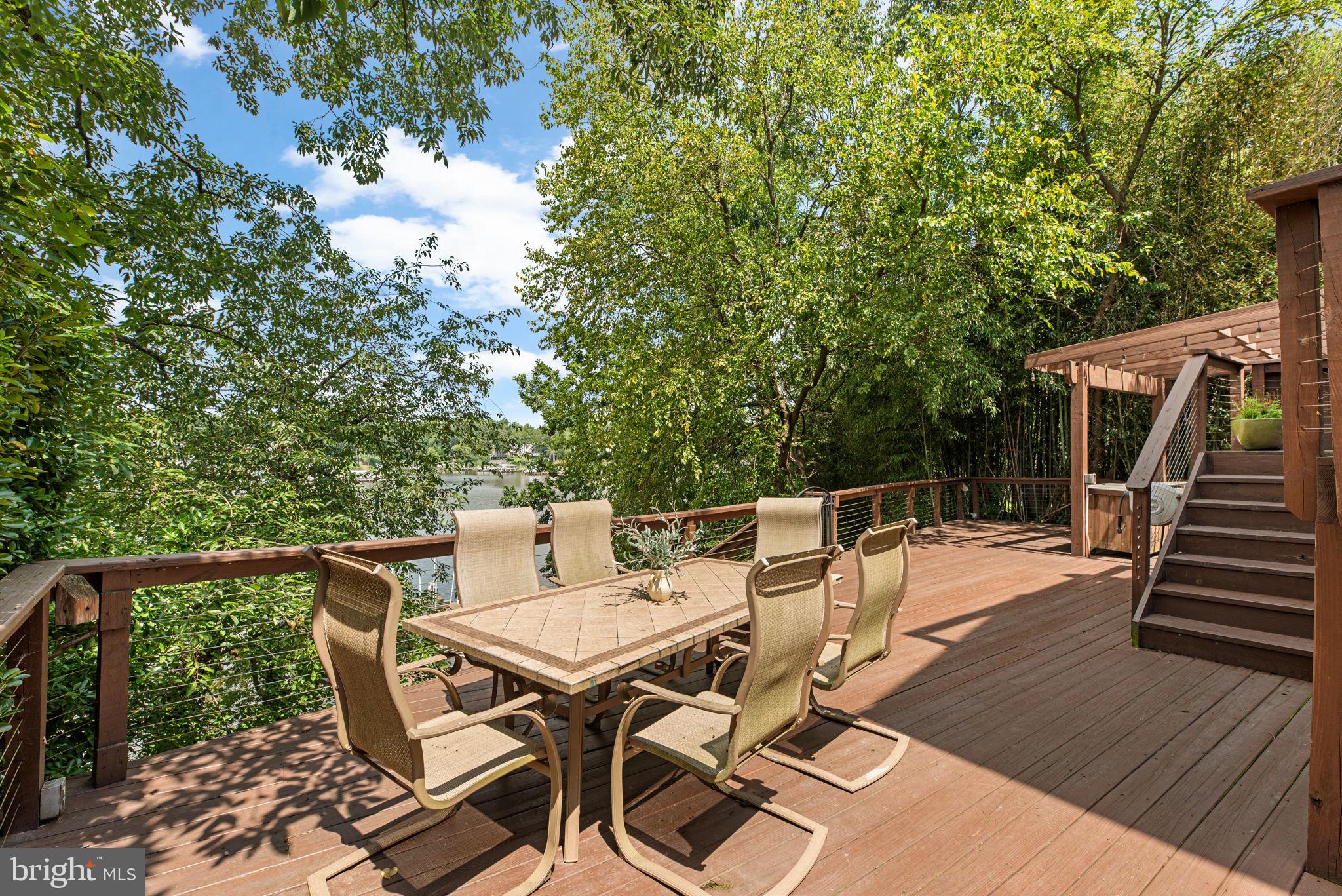 7674 Pine Knob Road Pasadena, MD 21122 - Photo 39 of 59 a view of a patio with table and chairs with wooden floor and fence