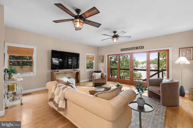 a living room with furniture floor to ceiling window and a flat screen tv