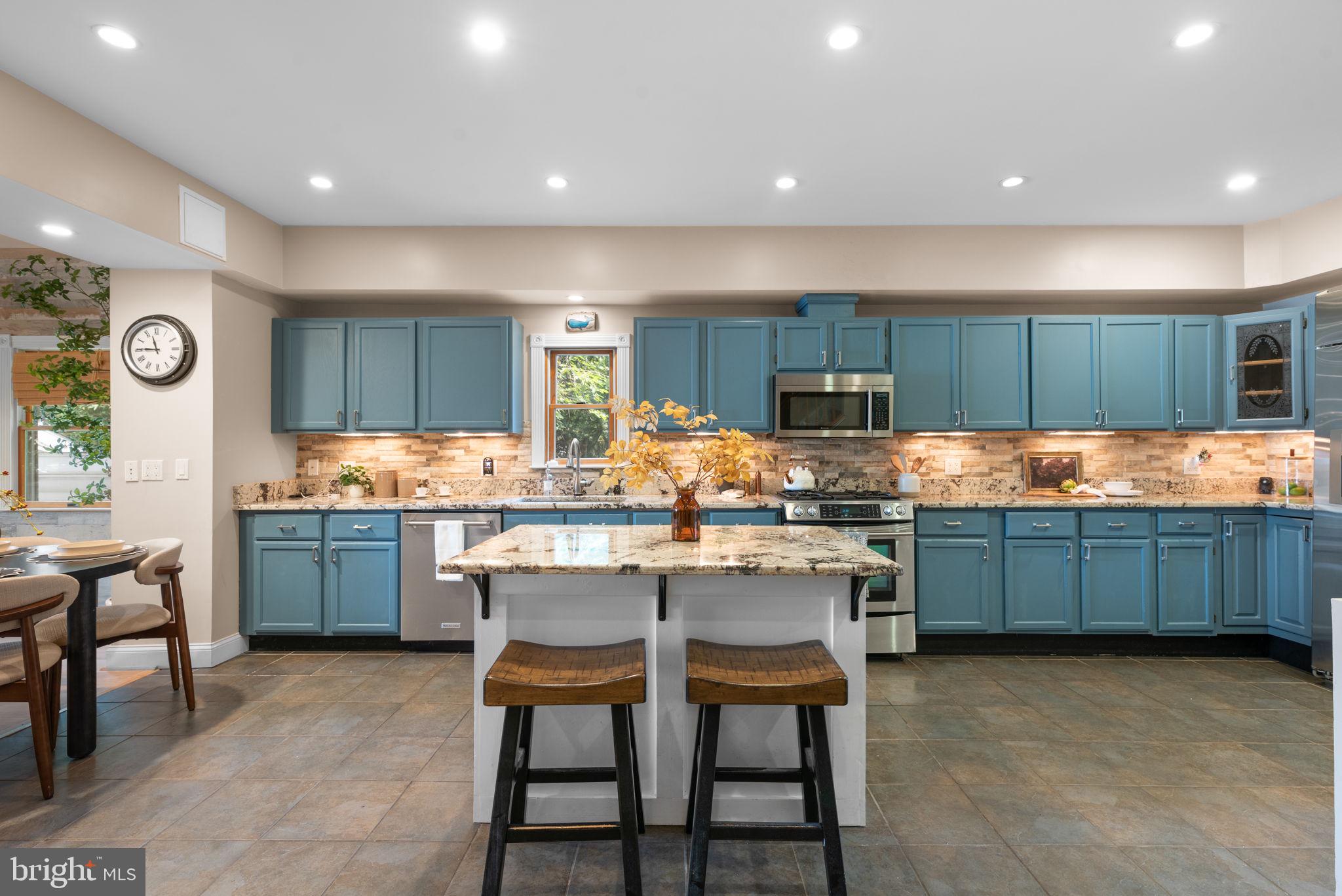 7674 Pine Knob Road Pasadena, MD 21122 - Photo 10 of 59 a kitchen with granite countertop a table chairs microwave oven stove and cabinets