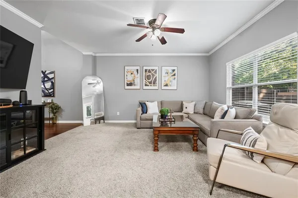 a living room with furniture a flat screen tv and a large window