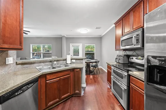 a kitchen with stainless steel appliances granite countertop sink stove top oven and cabinets